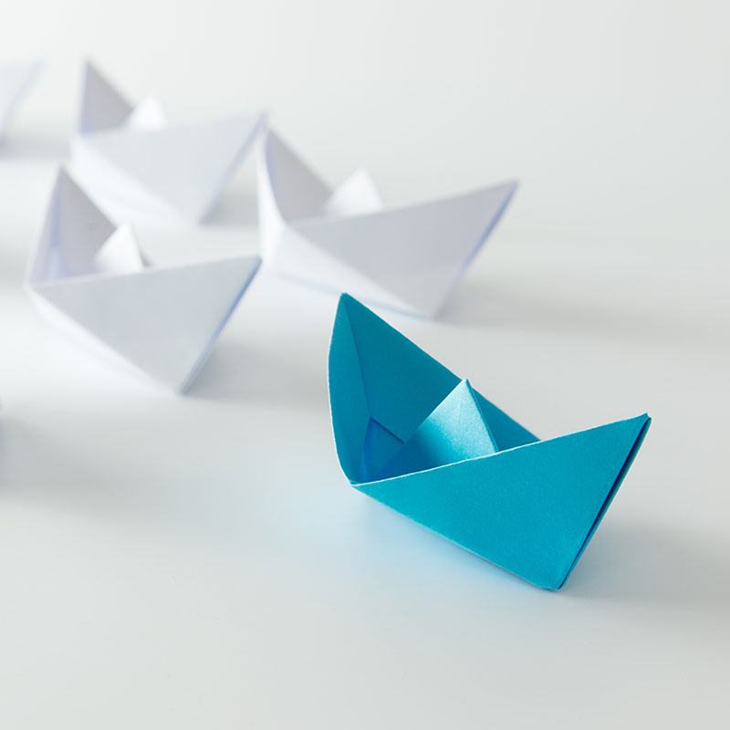 paper boats, with one leading the others